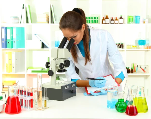 Unga forskare undersöker mikroskopet i laboratorium — Stockfoto