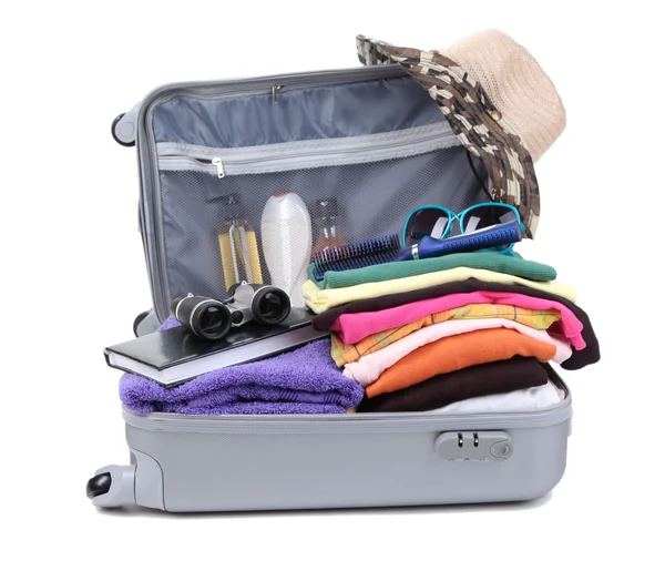 Открытый серебряный чемодан с одеждой, изолированной на белом — стоковое фото