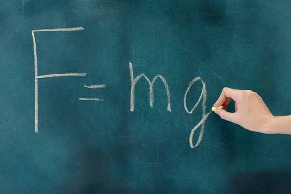 Fysik formel skrivs på tavlan med krita. — Stockfoto