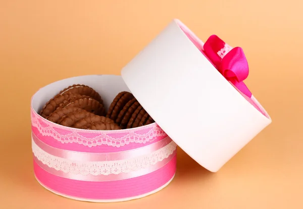 Biscotti al cioccolato con strato cremoso sulla scatola su sfondo beige — Foto Stock