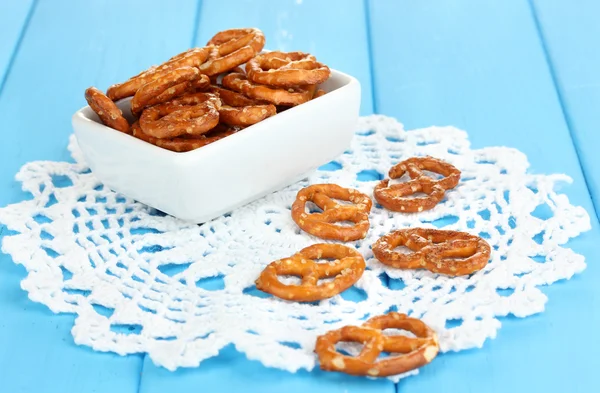 Tasty pretzels in white bowl on wooden table close-up — Stock Photo, Image