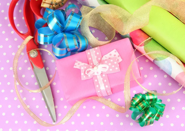 Rollos de papel de regalo de Navidad con cintas, lazos en el fondo de color —  Fotos de Stock