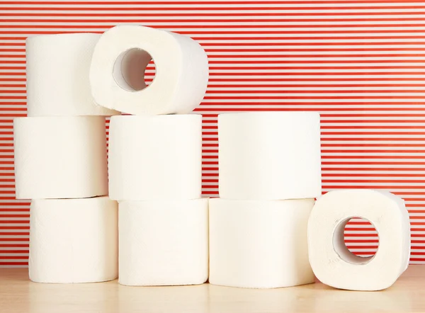 Rolki papieru toaletowego w paski czerwone tło — Zdjęcie stockowe