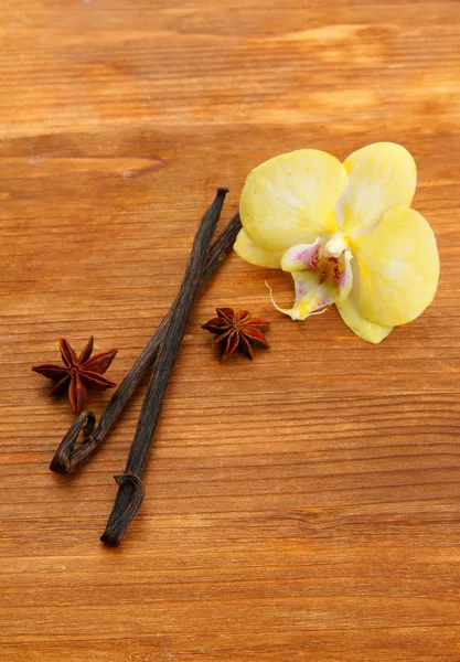 Cialde di vaniglia e anice con fiore, su fondo di legno marrone — Foto Stock