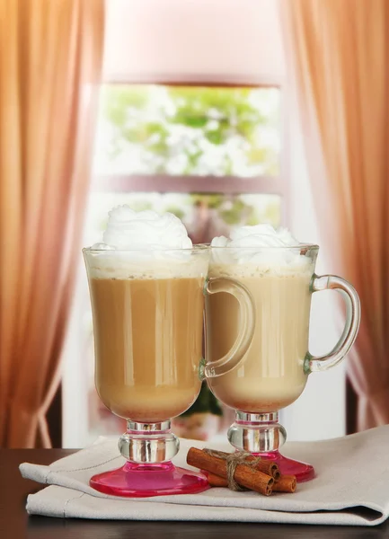 Fragrant coffee latte in glasses cups with vanilla pods, on table in cafe — Stock Photo, Image