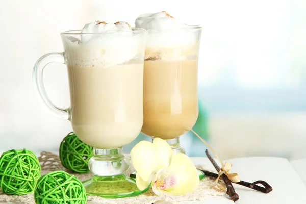 Café con leche aromática en vasos con especias, sobre mesa de madera —  Fotos de Stock