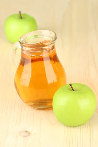 Full jug of apple juice and apple on wooden background — Stock Photo, Image