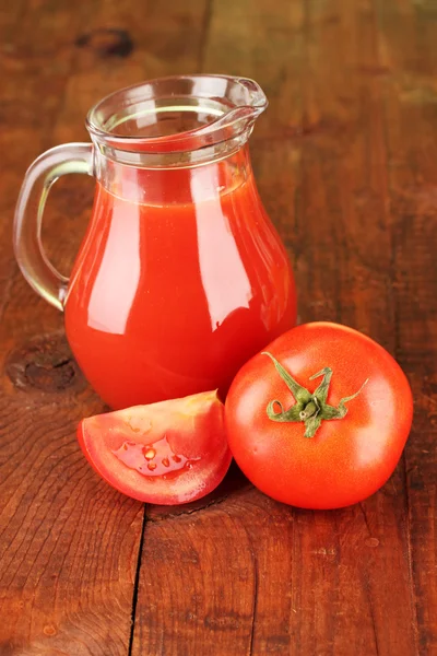 Full jug of tomato juice, on wooden background — Stock Photo, Image
