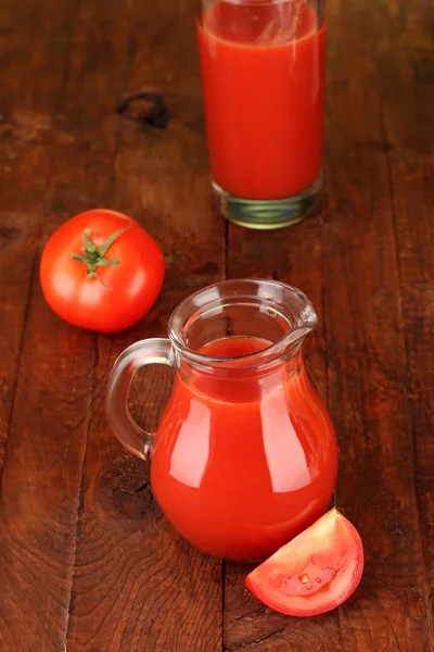 Full jug of tomato juice, on wooden background — Stock Photo, Image