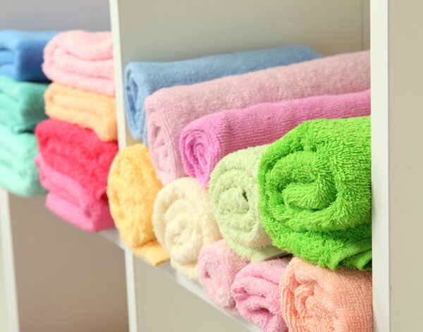 colorful towels on shelves in bathroom