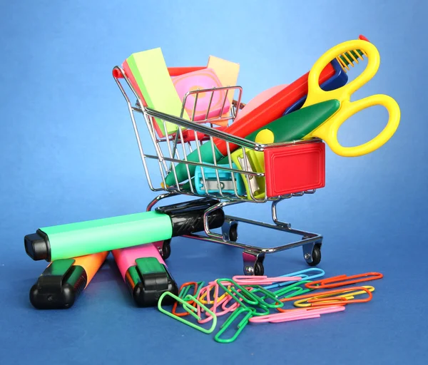 Trolley with school equipment on blue background — Stock Photo, Image
