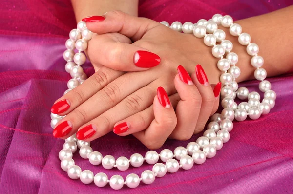 Mains féminines tenant des perles sur fond de couleur Images De Stock Libres De Droits