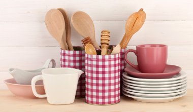 Cups, bowls nd other utensils in metal containers isolated on light background