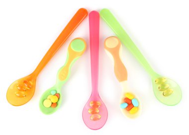 plastik kaşık ile üzerine beyaz izole renkli hapları
