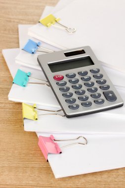 ahşap masa üzerinde bağlayıcı klipleri içeren belgeler