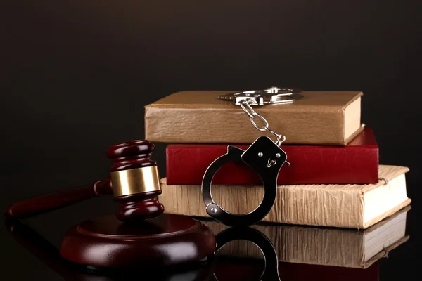 Gavel, manette e libri di legge isolati su nero — Foto Stock