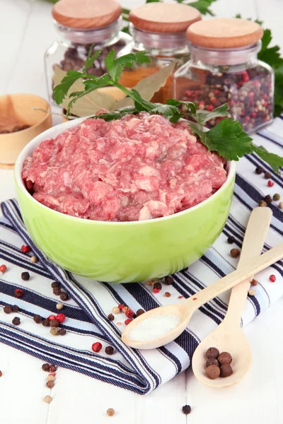 Tigela de carne moída crua com especiarias na mesa de madeira — Fotografia de Stock