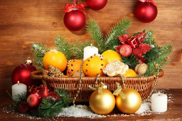 Julekomposition i kurv med appelsiner og grantræ, på træbaggrund - Stock-foto