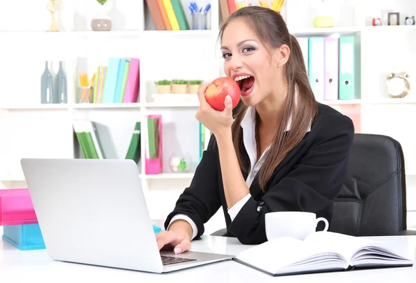 Joven empresaria comiendo una manzana — Foto de Stock