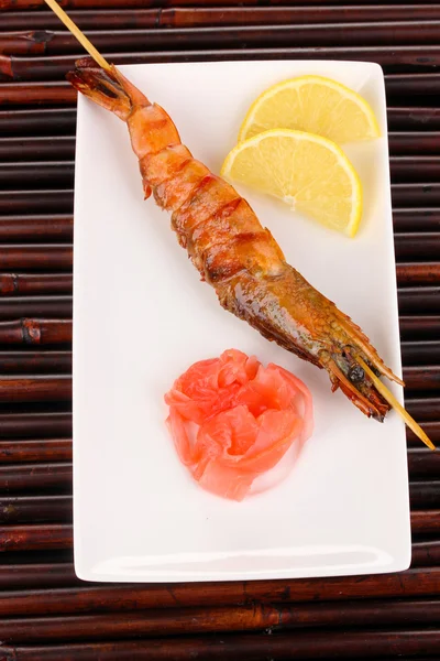 King prawn skewers on plate with ginger and lemon — Stock Photo, Image