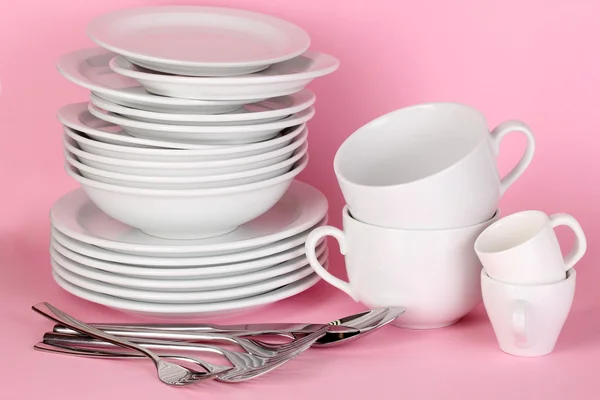 Clean white dishes on pink background — Stock Photo, Image