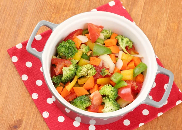 Ragoût de légumes en pot gris sur serviette de couleur sur fond en bois — Photo