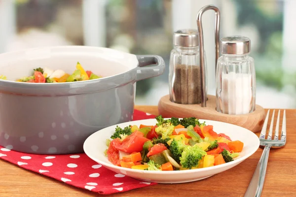 Ragoût de légumes en pot gris sur table en bois sur fond lumineux — Photo