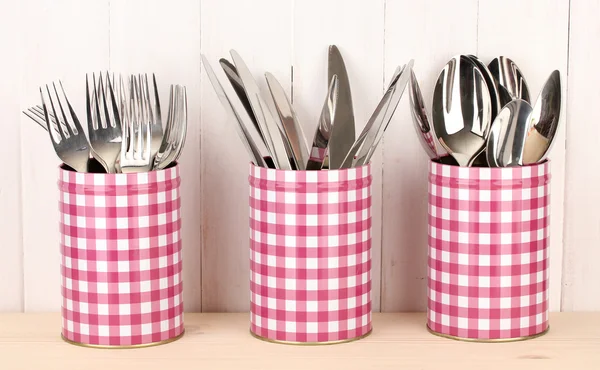 Utensils in metal containers isolated on light background — Stock Photo, Image