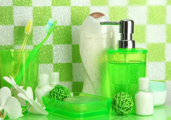 Kylpyamme tarvikkeet hyllyllä kylpyhuoneessa vihreällä laatta seinään tausta — kuvapankkivalokuva