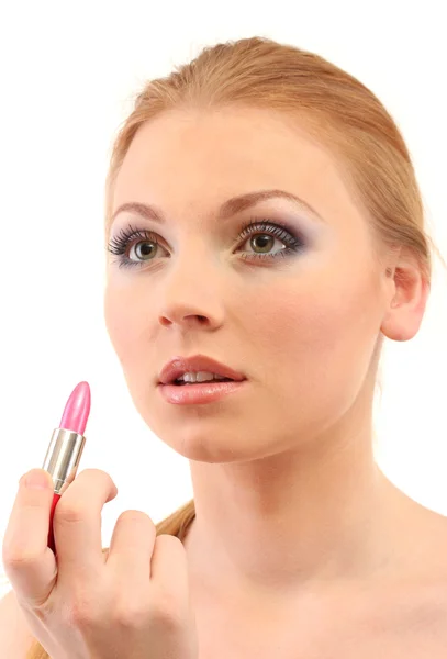 Hermosa mujer joven aplicando brillo de labios, aislado en blanco — Foto de Stock
