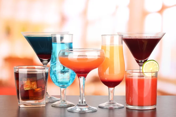 Several glasses of different drinks on bright background — Stock Photo, Image