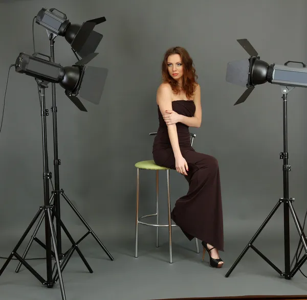 Beautiful professional female model resting between shots in photography studio shoot set-up — Stock Photo, Image