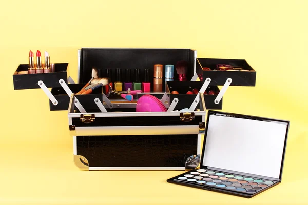 Open case with cosmetics on yellow background — Stock Photo, Image