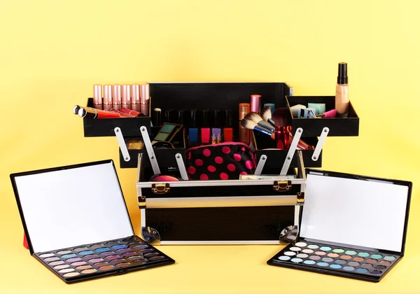 Open case with cosmetics on yellow background — Stock Photo, Image