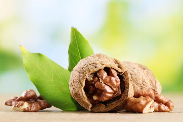 Nueces con hojas verdes, sobre fondo verde — Foto de Stock