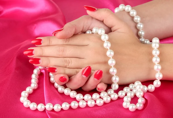 Mãos femininas segurando contas no fundo de cor — Fotografia de Stock