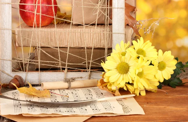 Autumnal composition with gift, books and leaves on bright background — Stock Photo, Image