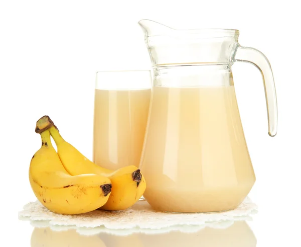 Verre plein et cruche de jus de banane et bananes isolées sur blanc — Photo