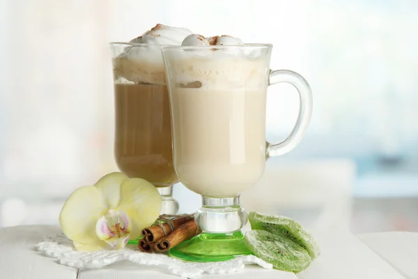 Fragrant coffee latte in glasses cups with spices, on wooden table — Stock Photo, Image