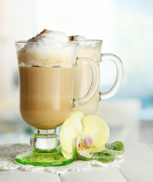 Geurende koffie latte in glazen bekers met kruiden, op houten tafel — Stockfoto