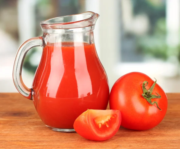 Volledige kruik van tomatensap, op houten tafel op lichte achtergrond — Stockfoto