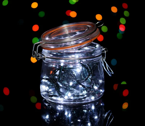 Luces de Navidad en botella de vidrio sobre fondo de luces borrosas —  Fotos de Stock