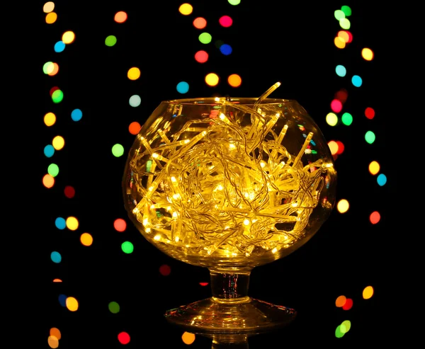 Christmas lights in glass bowl on blur lights background — Stock Photo, Image