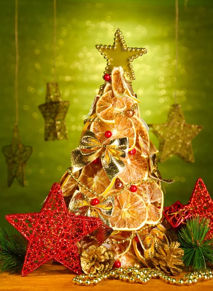 Hermoso árbol de Navidad de limones secos con decoración, sobre fondo verde brillante —  Fotos de Stock