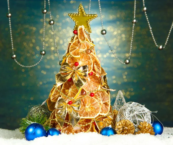 Hermoso árbol de Navidad de limones secos con decoración, sobre fondo azul brillante —  Fotos de Stock
