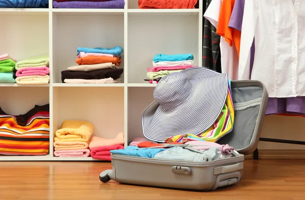 Valise ouverte en argent avec vêtements dans la chambre — Photo