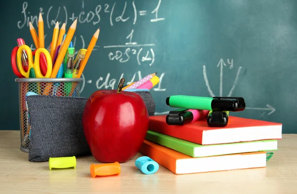 Volver a la escuela - pizarra con caja de lápiz y equipo escolar en la mesa — Foto de Stock