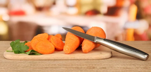 Mrkev s nožem na prkénko na stole v kuchyni — Stock fotografie