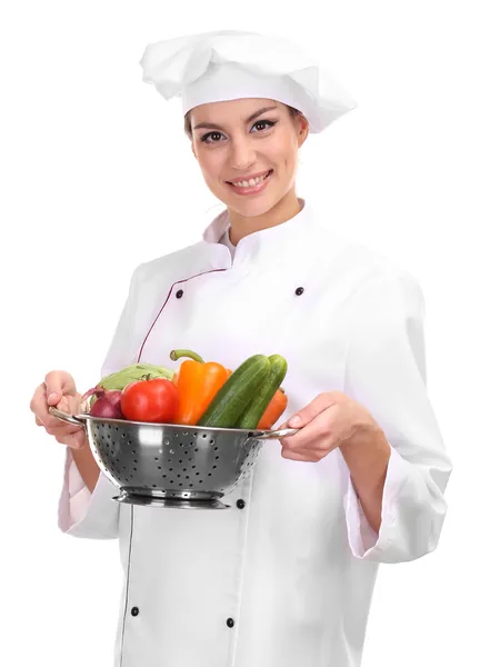 Portrait of young woman chef with vegetables isolated on white — Stock Photo, Image