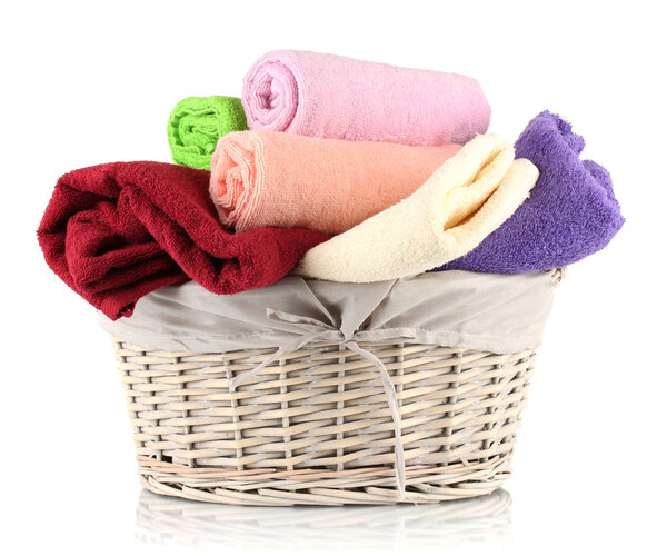 Colorful towels in basket isolated on white